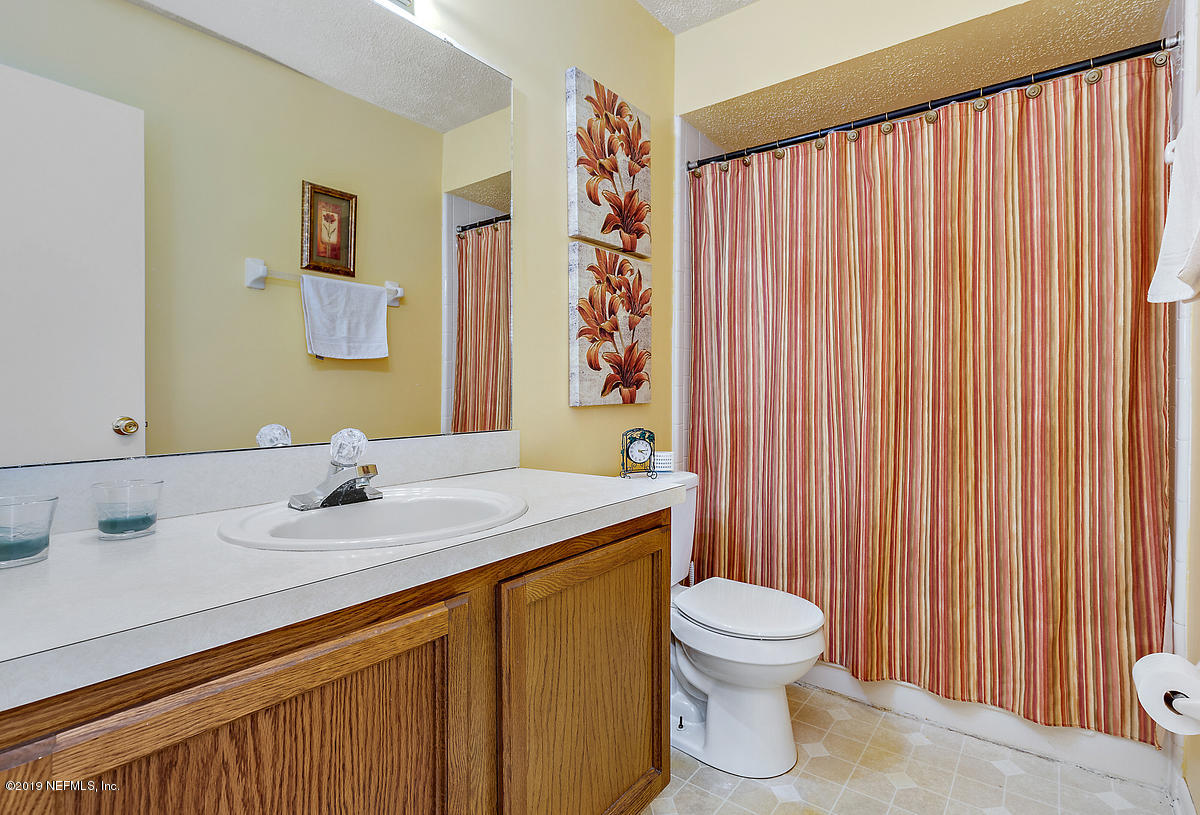 12819 Beaubien Road Jacksonville, FL 32258 - Photo 10 of 17 a bathroom with a sink a toilet and shower curtain