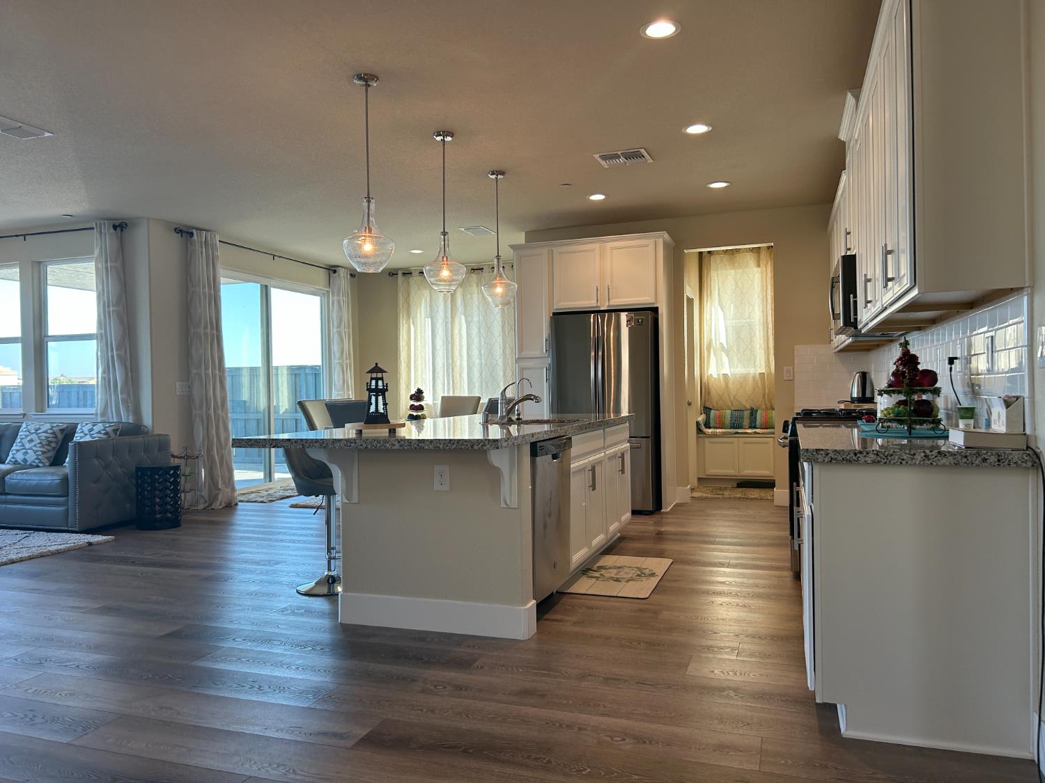 18006 Silver Springs Way Lathrop, CA 95330 - Photo 6 of 26 a large kitchen with a center island wooden floor stainless steel appliances and a window