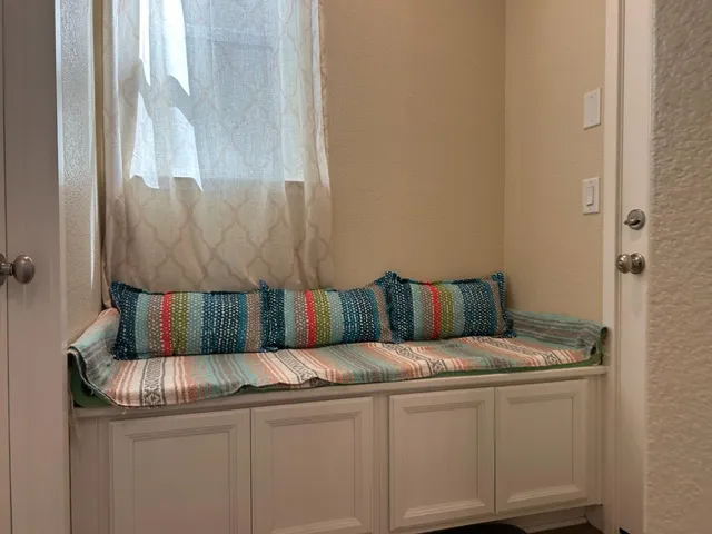 a bed sitting in a kitchen next to a window