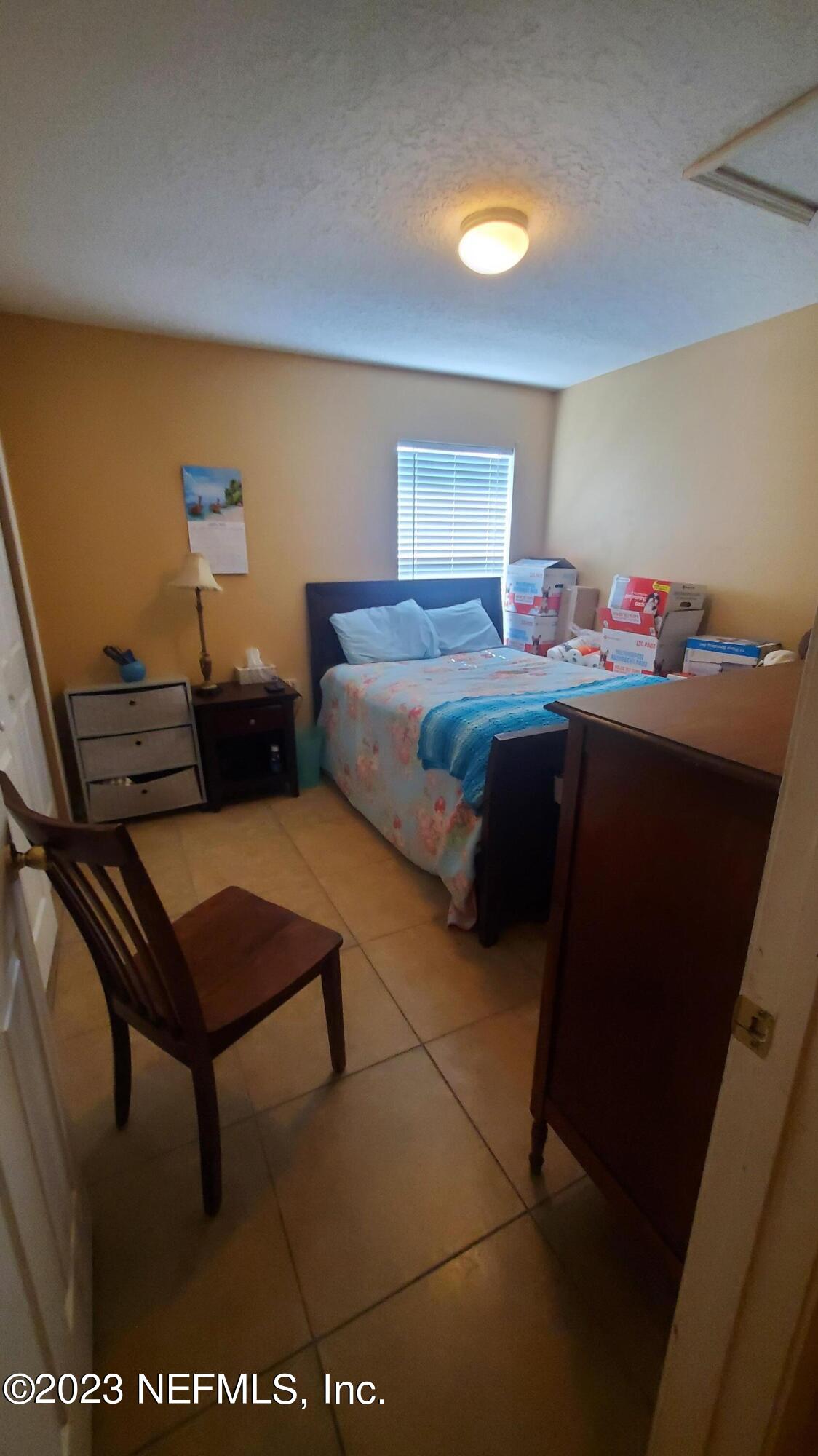 8205 Firetower Road Jacksonville, FL 32210 - Photo 7 of 11 a room with a bed and a lamp on table
