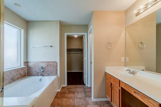 a bathroom with a tub sink and mirror
