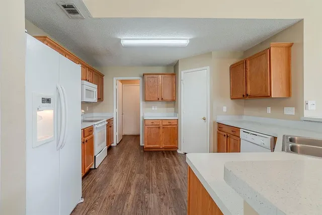 a kitchen with a refrigerator sink and wooden floor