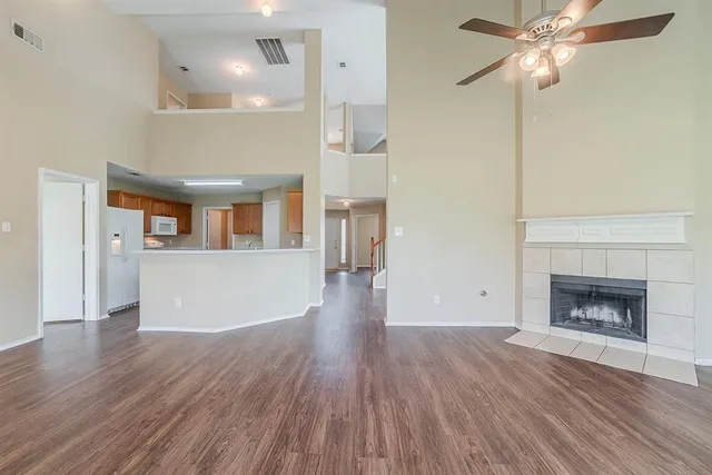 a view of a livingroom with wooden floor and a fireplace