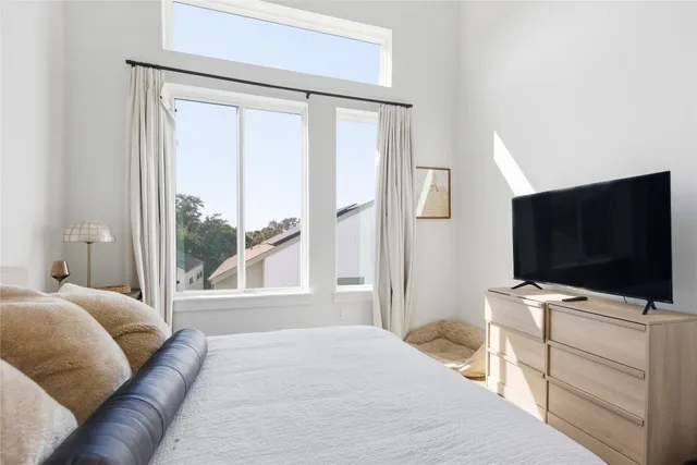 a bedroom with a bed lamp and a potted plant