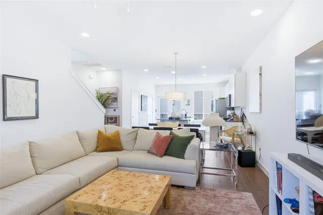 a living room with furniture kitchen view and a chandelier