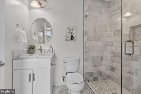 a bathroom with a toilet a sink and mirror