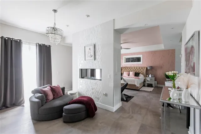 a living room with furniture a chandelier and a window