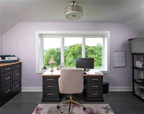 a view of a workspace with furniture and a window