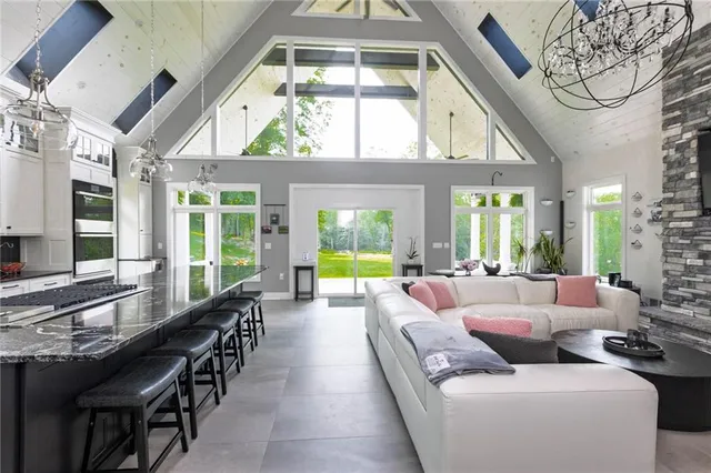 a living room with furniture a chandelier and a large window