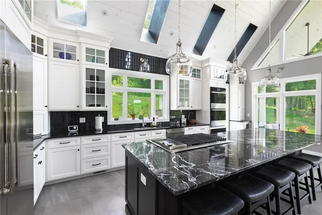 a kitchen with granite countertop a sink stove and cabinets