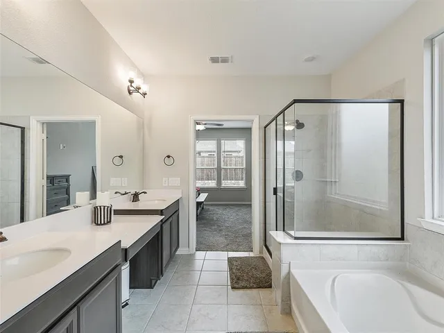 a spacious bathroom with a granite countertop sink mirror and shower
