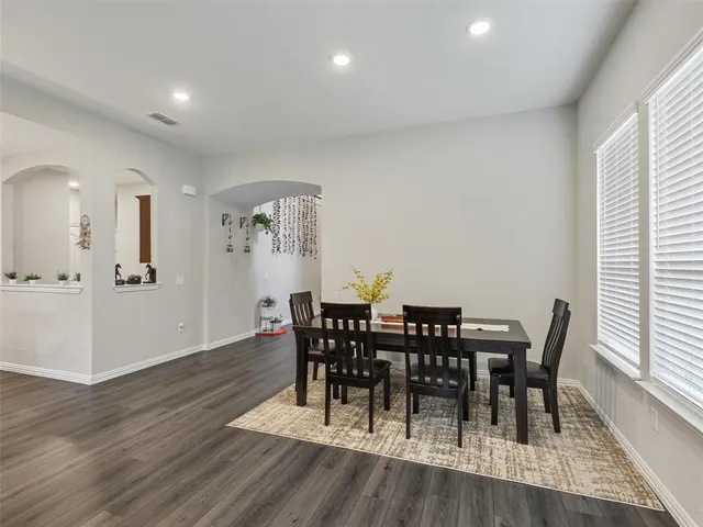 a view of a a dining room with furniture window and wooden floor