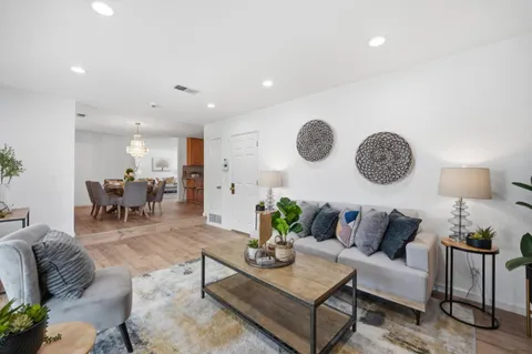 a living room with furniture a clock on wall and a table