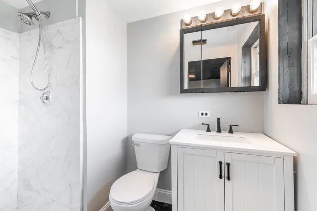 a bathroom with a sink vanity mirror and toilet