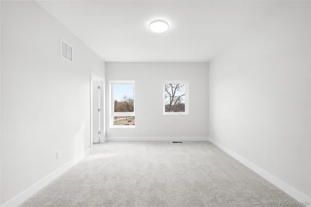 an empty room with windows and closet