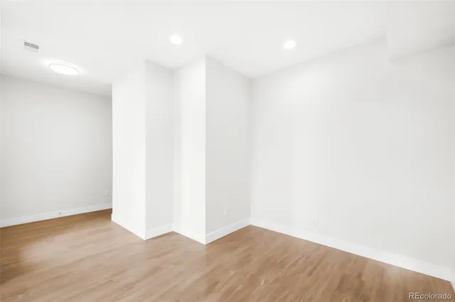 a view of an empty room with wooden floor