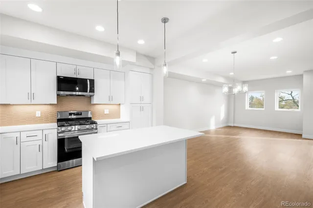 a kitchen with a stove a sink and a refrigerator