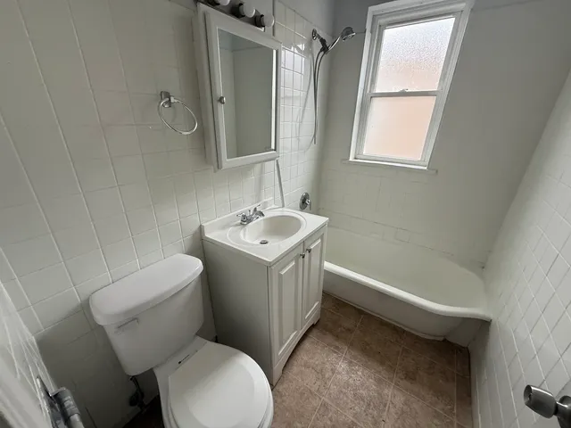 a white toilet sitting next to a bath tub