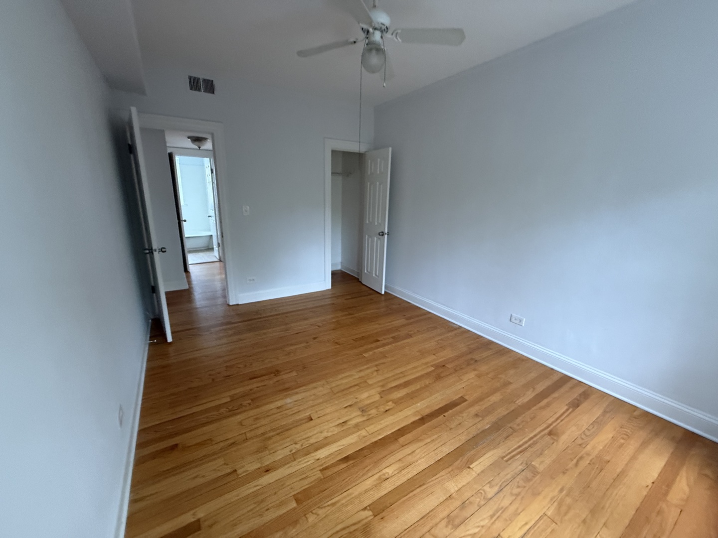 2004 West Jarvis Avenue, Unit 3 Chicago, IL 60645 - Photo 6 of 12 a view of empty room with wooden floor and fan