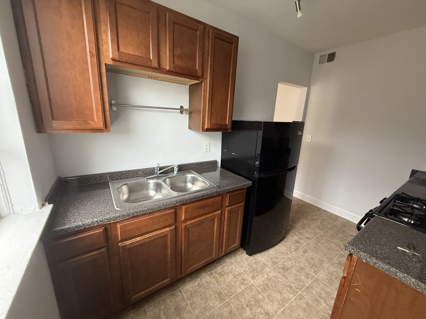 2004 West Jarvis Avenue, Unit 3 Chicago, IL 60645 - Photo 10 of 12 a kitchen with stainless steel appliances granite countertop a stove and a refrigerator