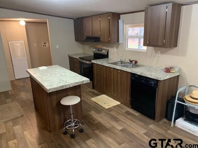 a kitchen with a sink refrigerator and cabinets