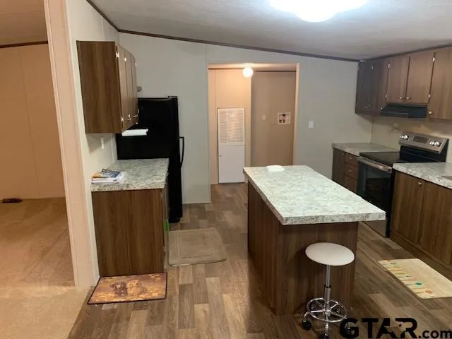 a kitchen with granite countertop a sink a stove and refrigerator