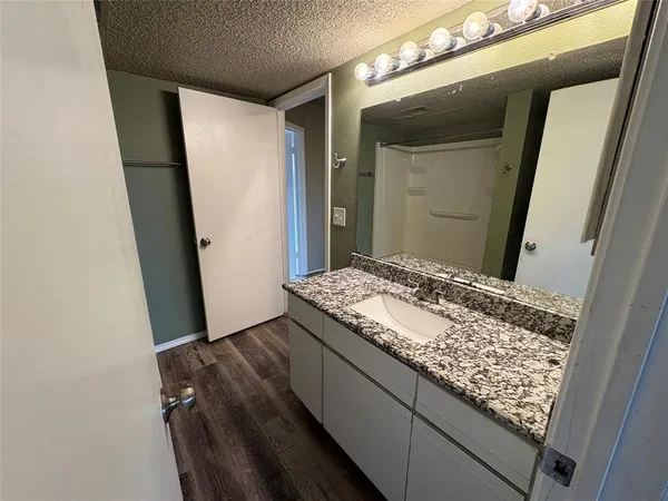 a bathroom with a granite countertop sink and a mirror