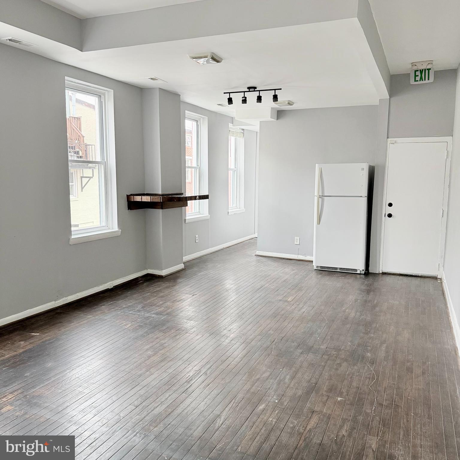 1001 Light Street, Unit 2 Baltimore, MD 21230 - Photo 5 of 11 an empty room with wooden floor and windows