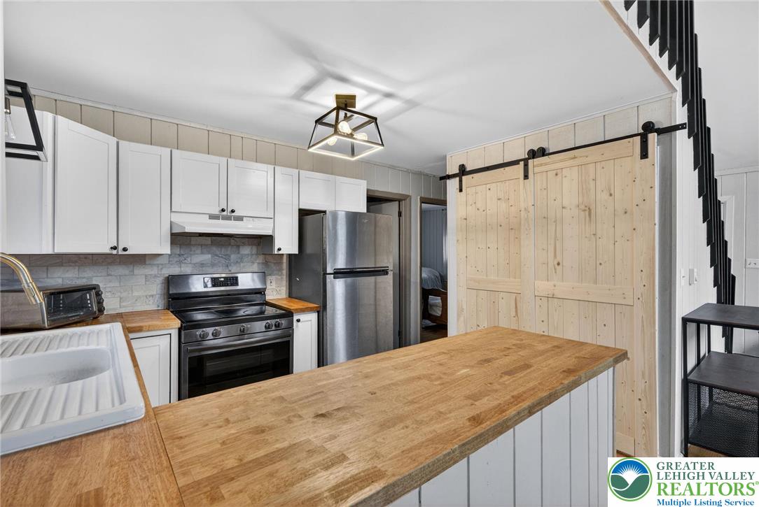 149 Regent Street Bushkill, PA 18324 - Photo 17 of 32 a kitchen with kitchen island white cabinets appliances and a counter top space