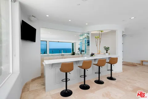 a view of kitchen island with stainless steel appliances kitchen island sink refrigerator and dining table