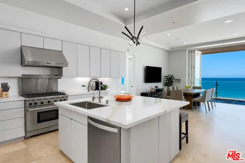 a kitchen with stainless steel appliances a stove a sink a microwave and a refrigerator