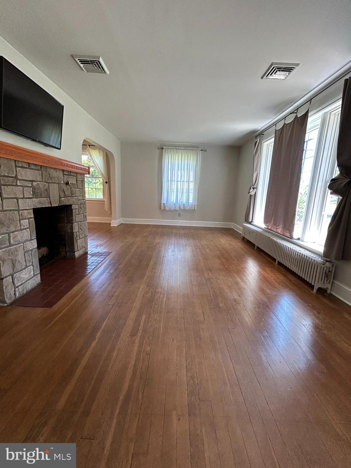 51 Homeland Road York, PA 17403 - Photo 3 of 45 an empty room with wooden floor fireplace and windows