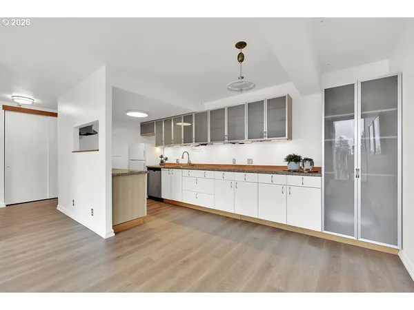 a view of a kitchen with wooden floor and a window