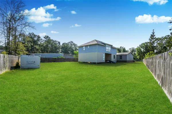 a view of a house with backyard and a tree