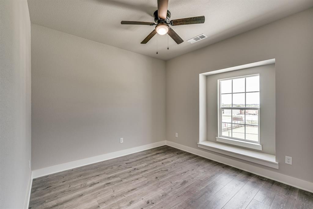 912 Cooksey Court, Unit A Grandview, TX 76050 - Photo 17 of 30 an empty room with wooden floor ceiling fan and windows
