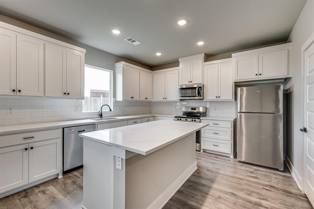 912 Cooksey Court, Unit A Grandview, TX 76050 - Photo 23 of 30 a kitchen with refrigerator cabinets and a sink