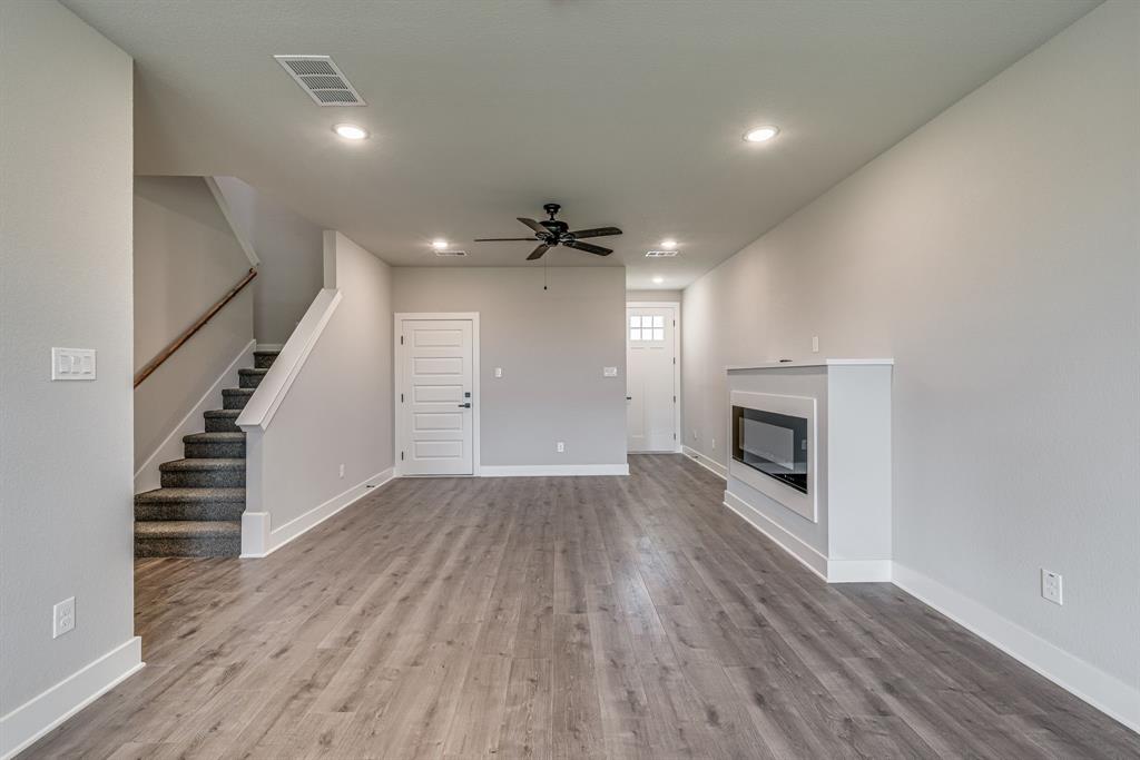 912 Cooksey Court, Unit A Grandview, TX 76050 - Photo 25 of 30 wooden floor in an empty room with a fireplace