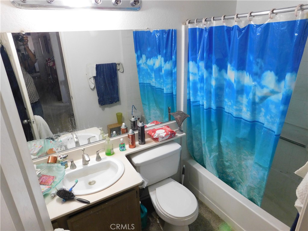 2368 Bayberry Way Hemet, CA 92545 - Photo 2 of 13 a bathroom with a sink a toilet and shower curtain