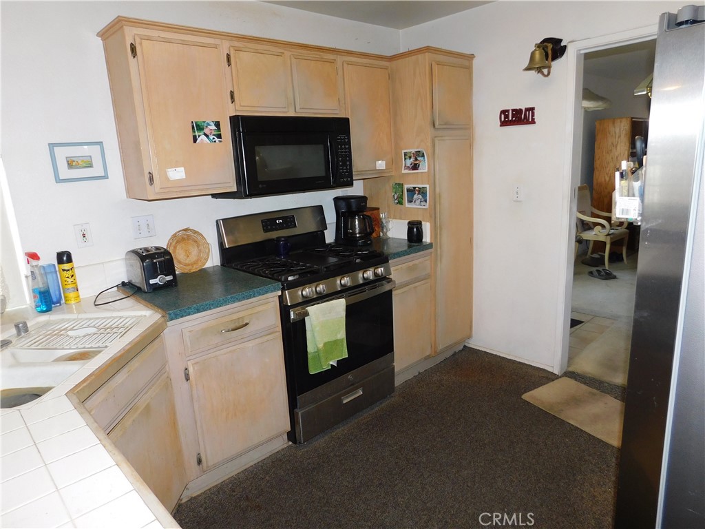2368 Bayberry Way Hemet, CA 92545 - Photo 7 of 13 a kitchen with stainless steel appliances a refrigerator stove and microwave