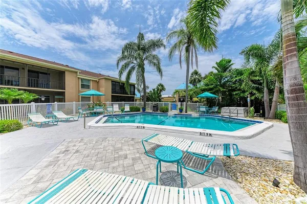 a view of backyard with swimming pool and seating