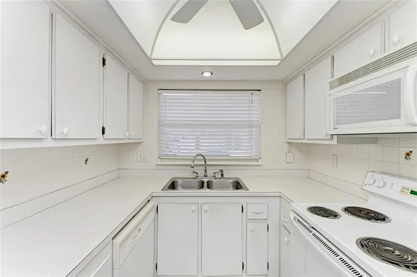 a kitchen with a sink a stove cabinets and a window