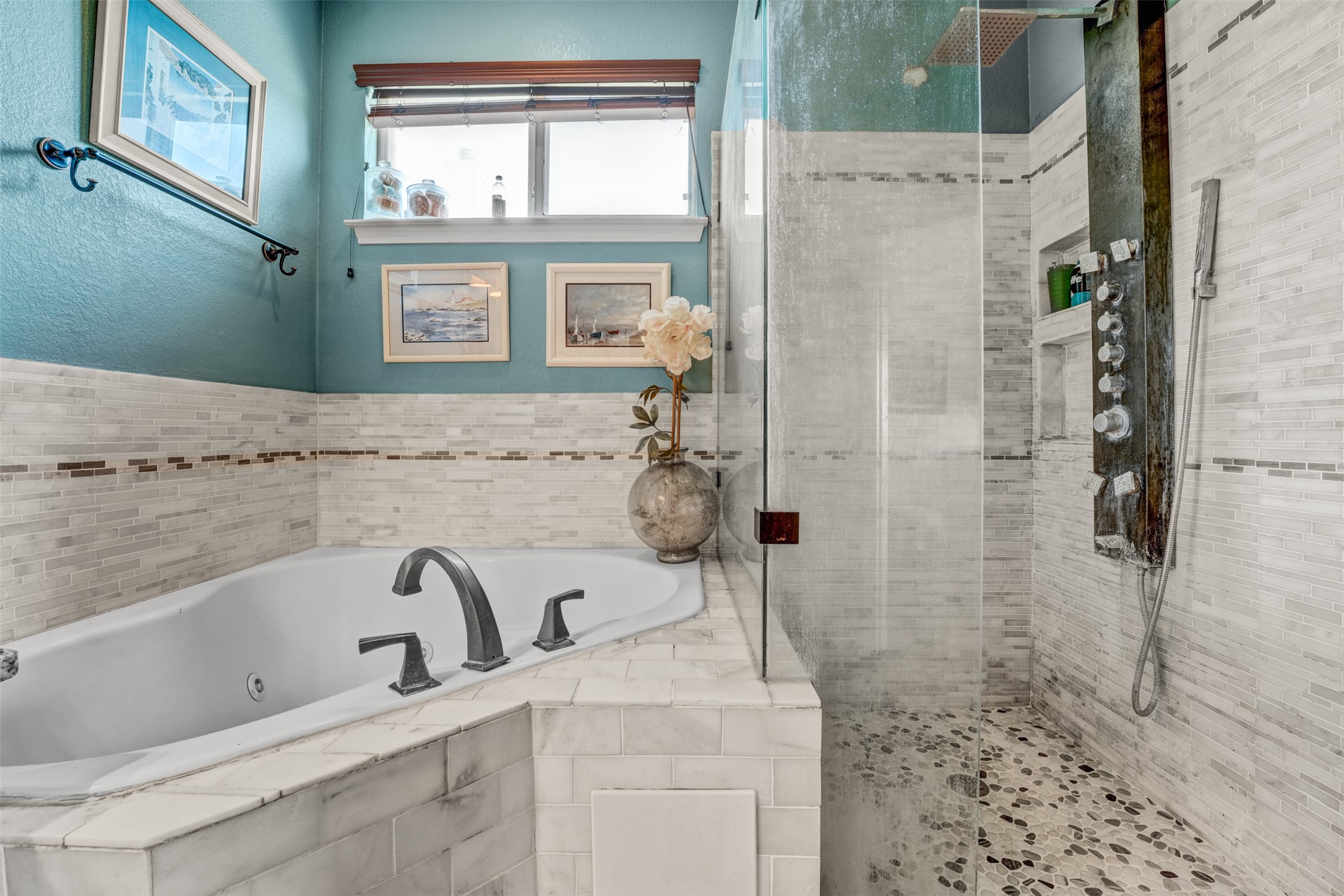 2521 Amen Corner Road Pflugerville, TX 78660 - Photo 22 of 40 Spacious bathroom featuring a corner soaking tub with deck-mounted faucet, a glass-enclosed shower with pebble-tiled floor, and a multi-function shower panel