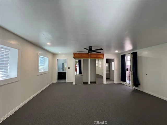 an empty room with windows and fireplace