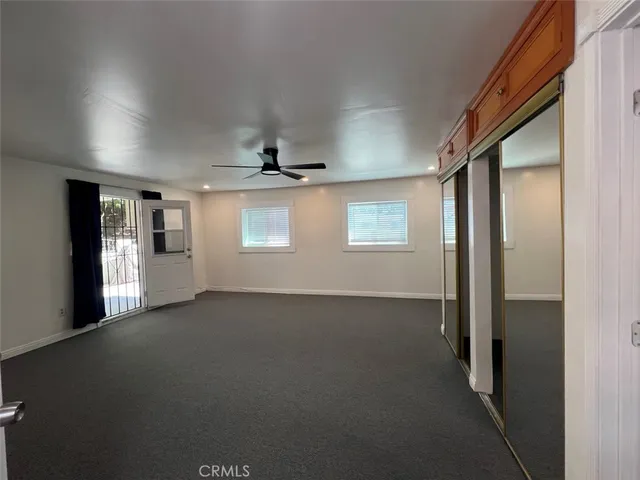 en empty room with windows and ceiling fan