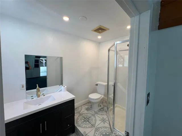 a bathroom with a double vanity sink toilet and mirror