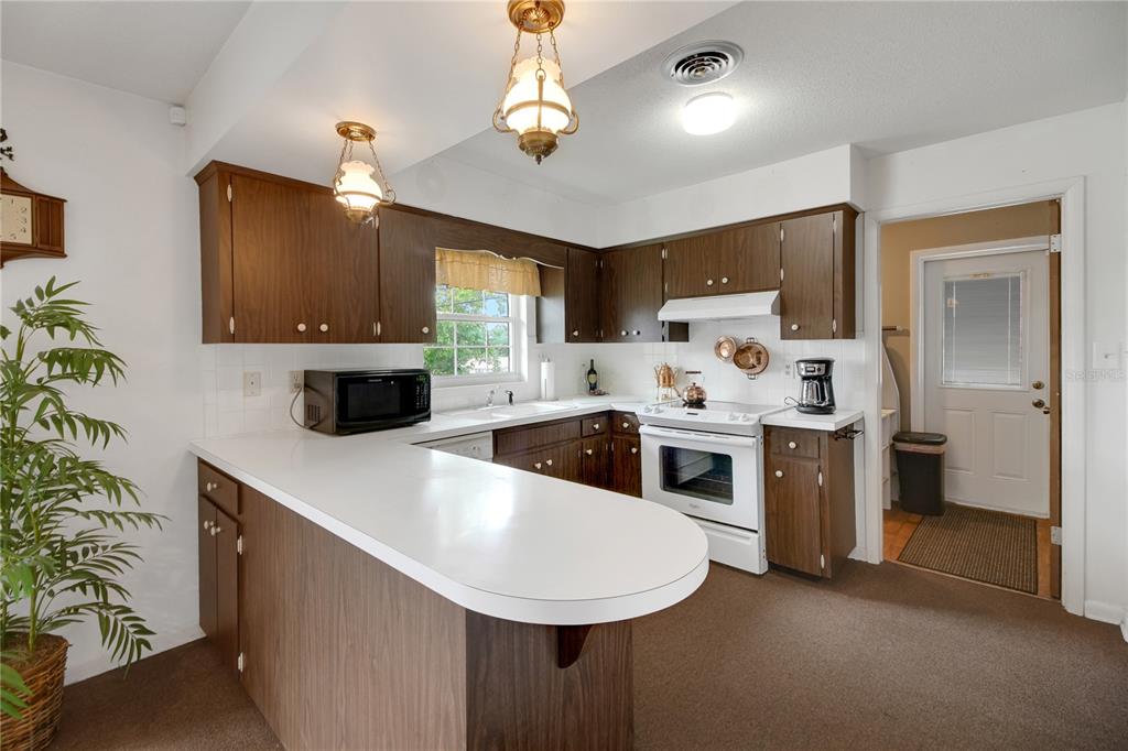 2214 Topping Place Eustis, FL 32726 - Photo 20 of 57 a kitchen with stainless steel appliances a white table chairs and a refrigerator
