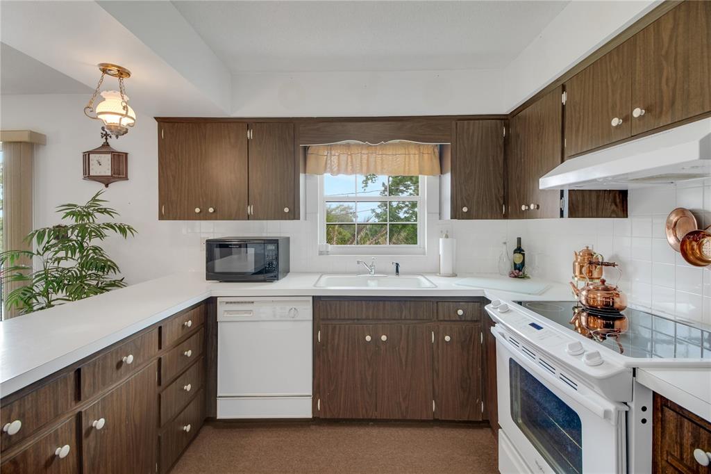 2214 Topping Place Eustis, FL 32726 - Photo 22 of 57 a kitchen with a sink stove and cabinets