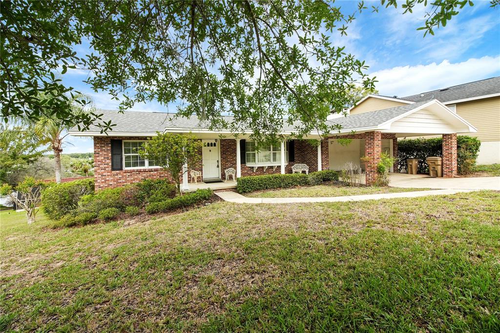 2214 Topping Place Eustis, FL 32726 - Photo 3 of 57 a front view of a house with a yard and palm trees
