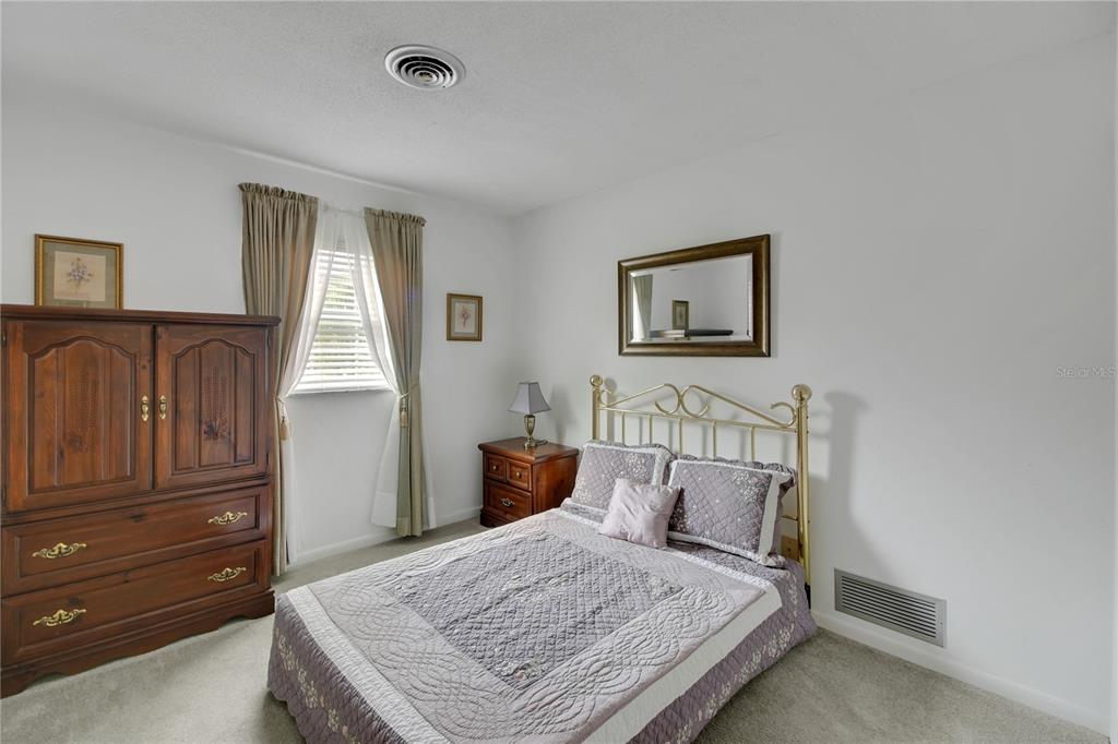 2214 Topping Place Eustis, FL 32726 - Photo 34 of 57 a bedroom with a bed and wooden floor