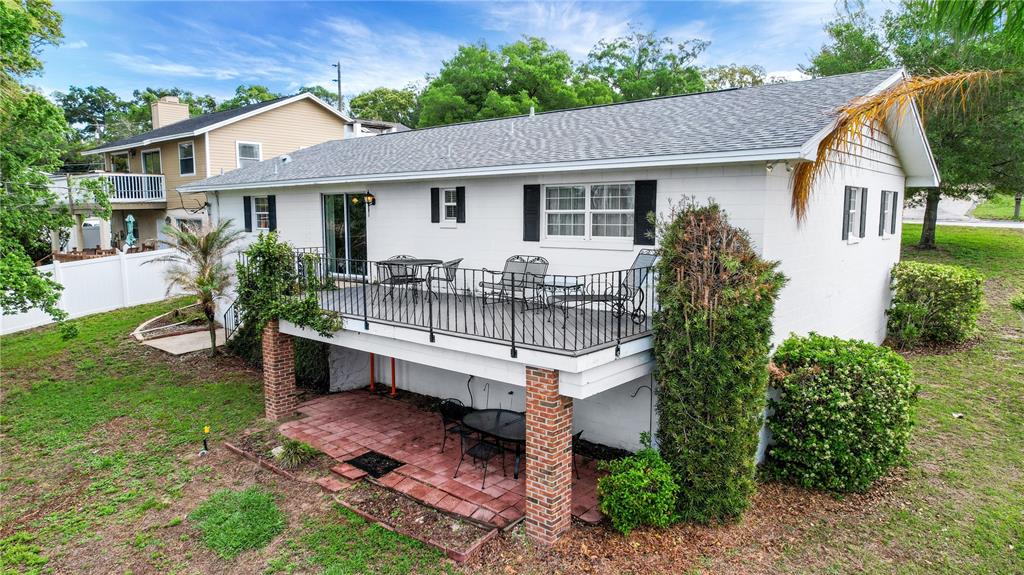 2214 Topping Place Eustis, FL 32726 - Photo 43 of 57 a white house that has a small yard and large trees